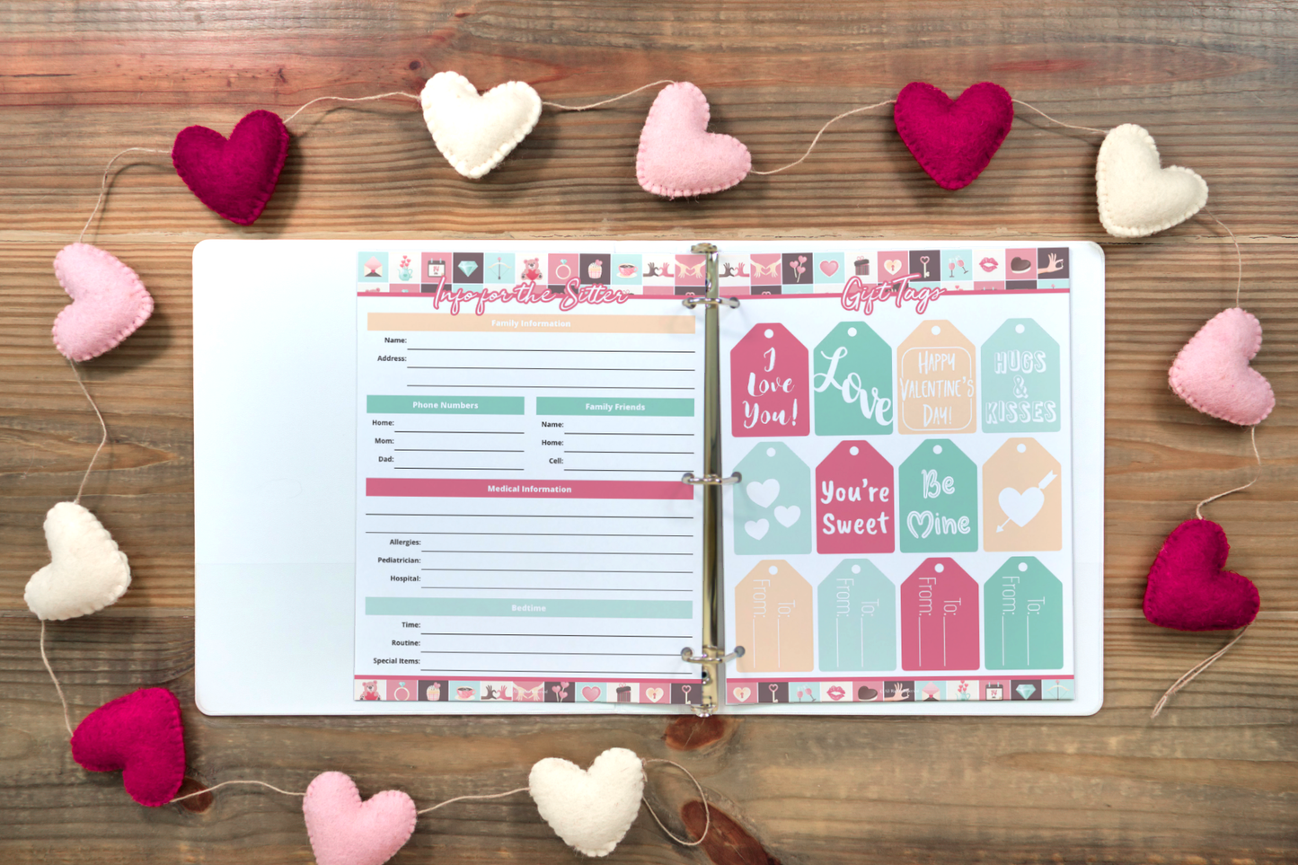 An open Valentine's Planner from Organized 31 Shop rests on a wooden surface, its themed pages accompanied by a string of pink, red, and white heart-shaped decorations. This charming digital product doubles as delightful wall art for the romantic season.