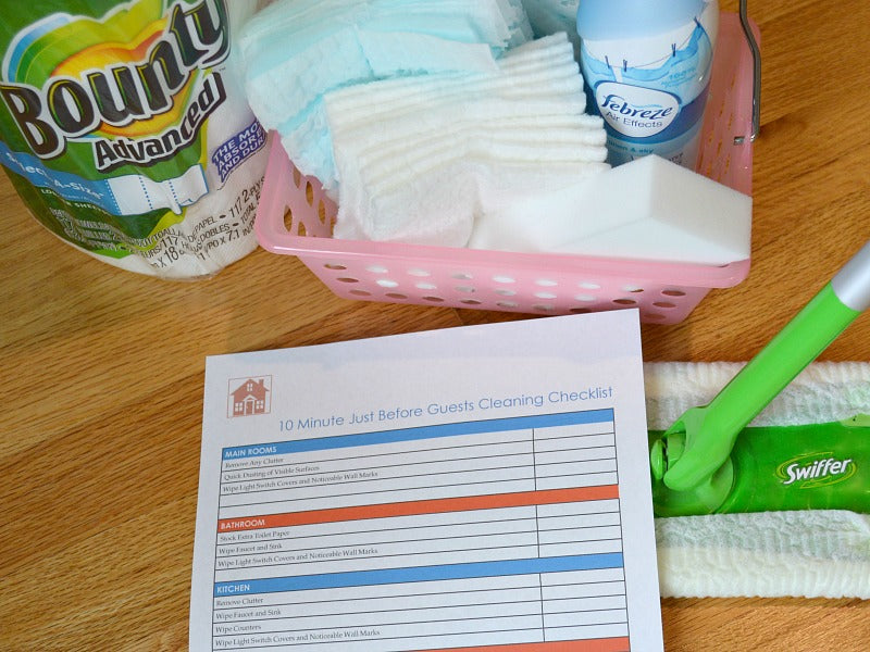 A list of cleaning supplies and a 10 Minutes Before Guests House Cleaning Checklist by Organized 31 Shop on a table.